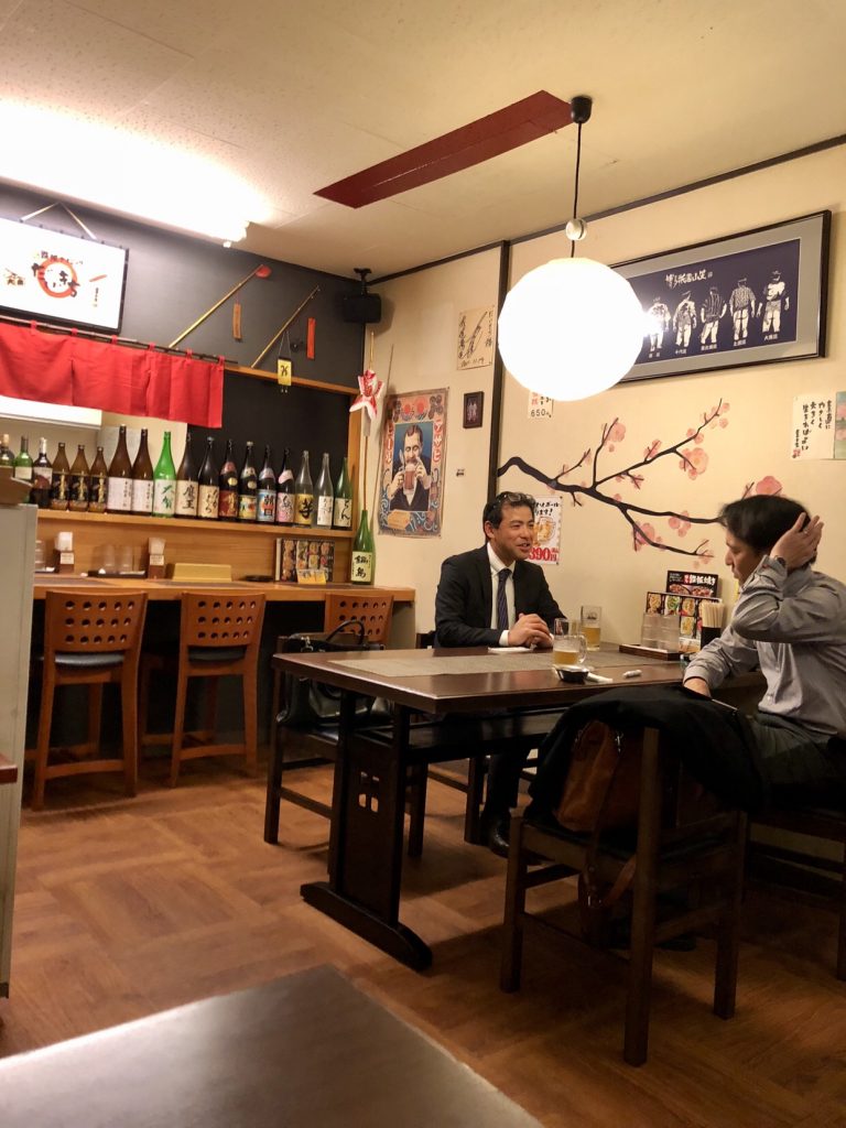Japan izakaya locals having sake at an izakaya bar